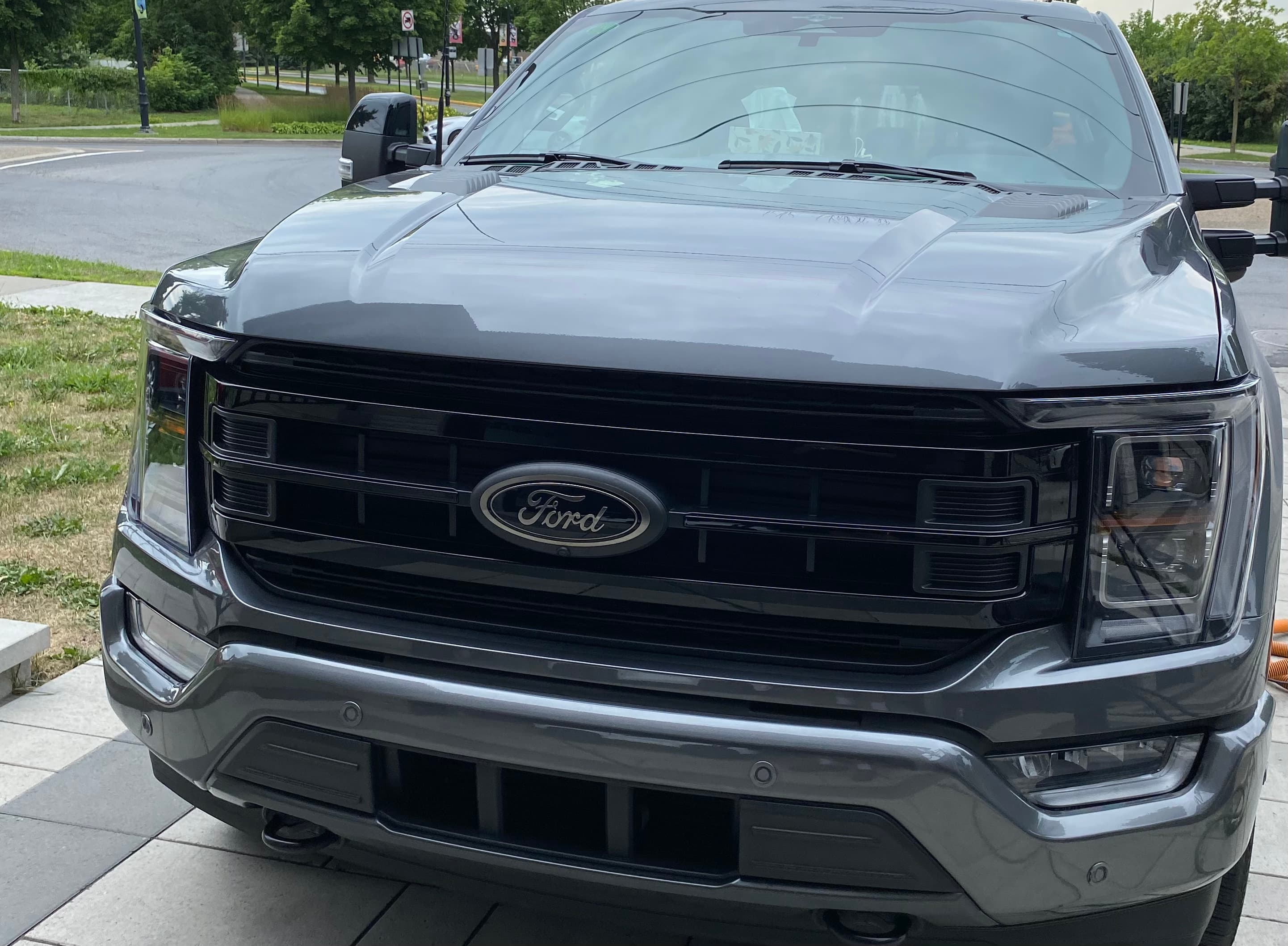 Front view of a dark gray Ford pickup truck featuring a black grille and emblem.